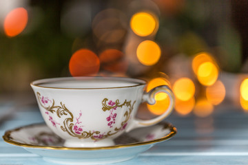 Tea Cup and Saucer on Wooden table with bokeh light background