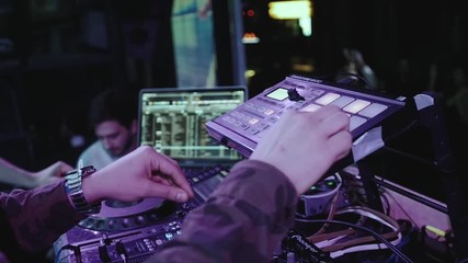 Close up of dj playing party music on modern cd usb player in disco club - Nightlife and entertainment concept - Defocused background with shallow depth of field and focus on buttons near mixing hand