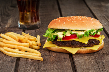 Fast food. Cheeseburger and french fries on a wooden background