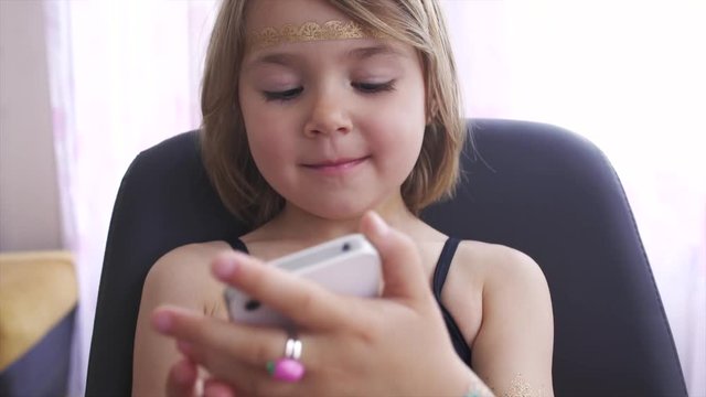 4-year-old girl grimaces and doing selfie indoor 4K