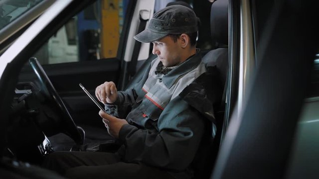 Car mechanic using tablet in car