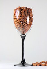 Glass full of borlotti beans on a white background.