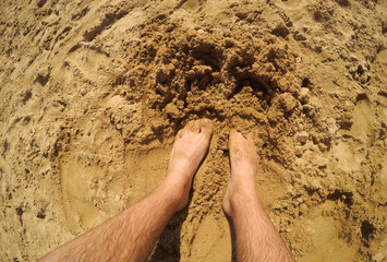 Barefoot man standing in the beach sand