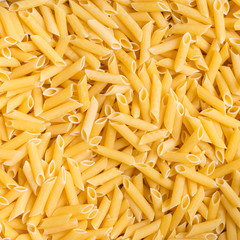 yellow dry penne pasta background