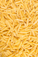 yellow dry penne pasta background