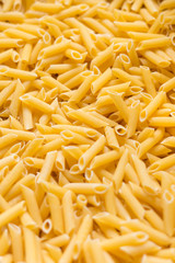 yellow dry penne pasta background