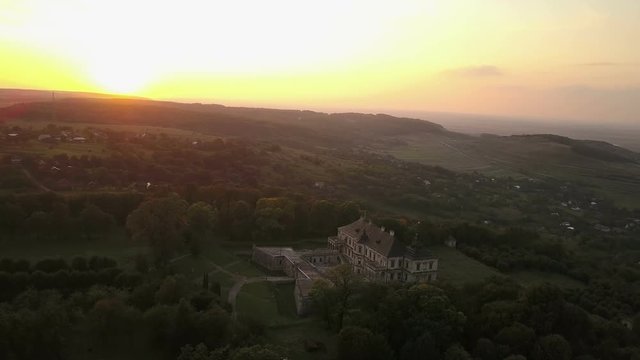 Aerial footage of summer sunset above the Pidhirtsi Castle in general shot with green forest and fields (4K, 25fps)