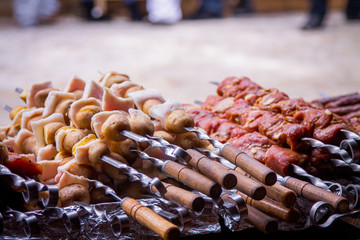 Street food. skewers with meat, potatoes and bacon. Cooking on an open fire