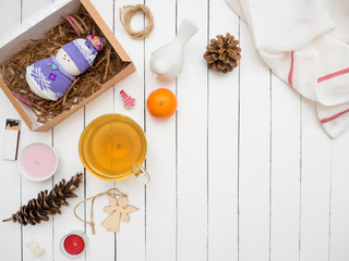 Glass cup of green tea and tangerine on a white wooden table