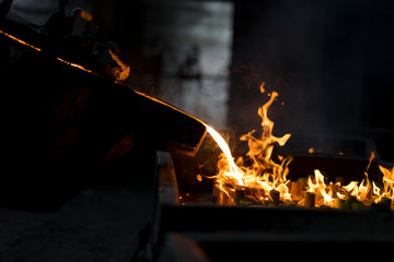 Molten metal casting, operator pouring metal casting parts from ladle in foundry