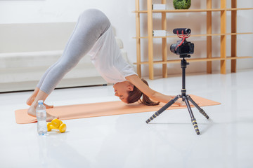 Deep relaxation. Calm young yoga teacher leaning to the floor while doing exercises on a mat and...