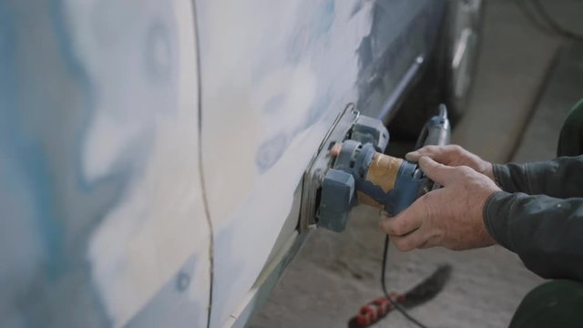 Crop hands sanding car