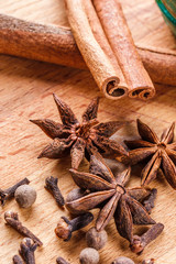 Anise stars, cinnamon sticks, cloves on a wooden cutting board