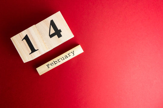 St. valentines day minimal concept on red background . wooden caledar with 14 february on it. Copy space