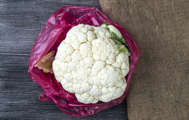 cauliflower vegetable, whole cauliflower stands on wooden floor
