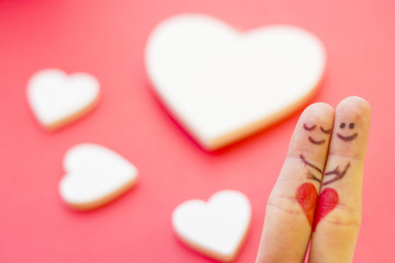 Fototapeta premium St. Valentine's Day concept with finger art happy couple hugging and hearts, red background, close up