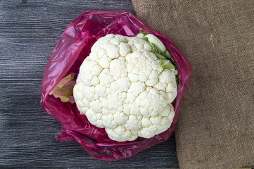cauliflower vegetable, whole cauliflower stands on wooden floor
