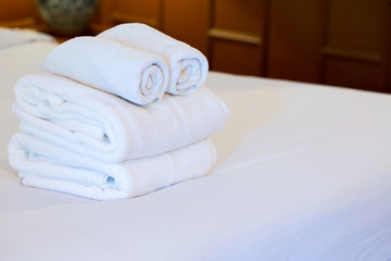 Fototapeta na wymiar White towel on bed decoration in bedroom