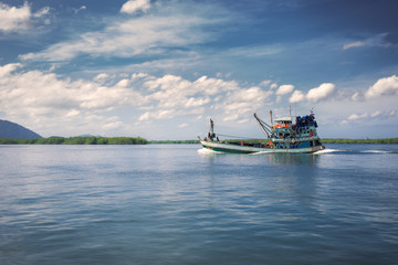 Obraz premium Fishing boat heading out to ocean in the morning.