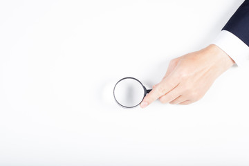 A man hand holding magnifying Glass on white background.