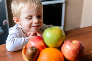 Fototapeta na wymiar The child looks for fruit and smiles.