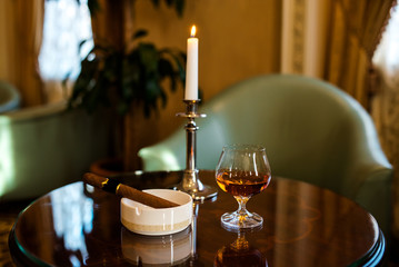 Cognac and a cigar on the table.
