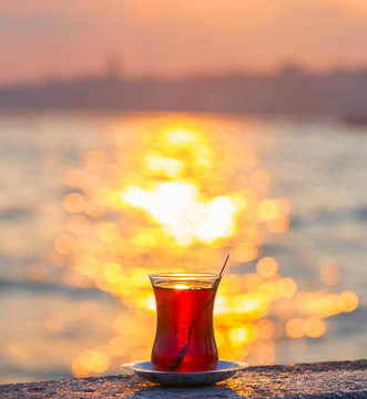 A cup of Turkish tea against the backdrop of the sunset and the Bosporus Strait