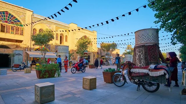 Zand walk street located between two covered parts of Vakil Bazaar, it's decorated with plants in pots and showcases of local stores, Shiraz, Iran