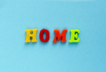 word "home" of plastic magnetic letters on blue background