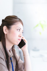 窓際で通話をする若い女性