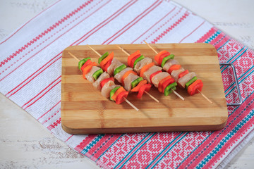 Shish kebab from chicken with pepper on a skewer prepared in an oven on a bright napkin