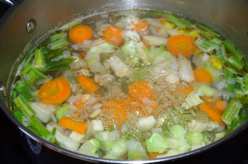 Pot with boiling water with fresh cut vegetables