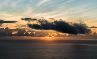 Obraz premium The sun and its last beams during a sunset on an island over the ocean