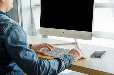 Close up business man top view working personal computer sitting wooden table desktop office window skyscraper. Male hands using smart phone typing computer keyboard start up.