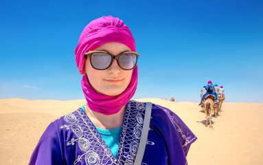 Beautiful woman in arabic traditional clothing against Sahara desert background. Tunisia, North...