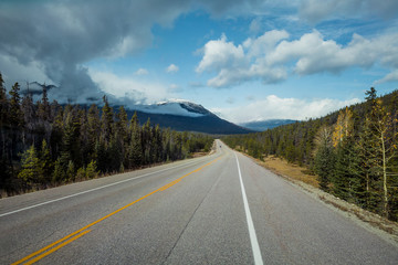Highway in den Rocky Mountains mit Bergen und Wolkenhimmel