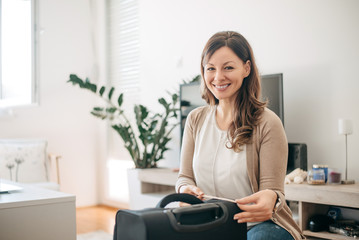 Brunette woman measuring her cabin luggage.
