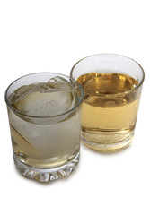 Glass jars with whiskey and ice on white background