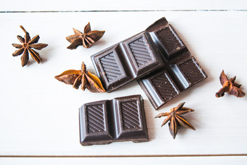 Close up of annis and dark chocolatea on white wooden table.