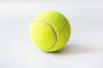 Close up of green tennis ball on a white background. Sport symbol of big tennis.