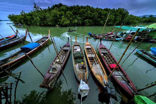 Beautiful sunrise landscape view of fisherman and wooden boat  at Mudong fishing village in Vichit Phuket,Thailand