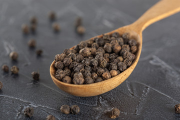black ground pepper in a wooden spoon