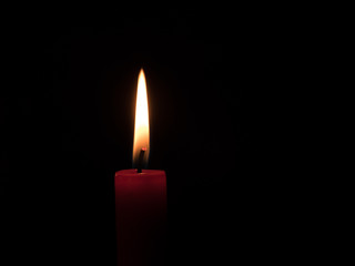 flame of a candlelight in the darkness