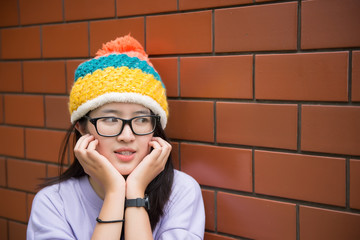 Portrait of thai woman golden hairs japan style on orange brick wall,Asian girl pose for take a picture outdoor