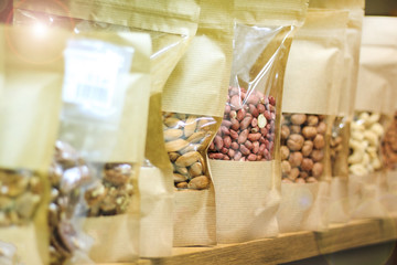 healthy lifestyle, clean and natural food. Nuts - raisins, peanuts, hazelnuts. packed in paper bags, stand on the counter in the store.
