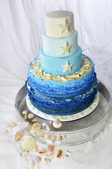Wedding cake with sea decorations with shells and blue waves