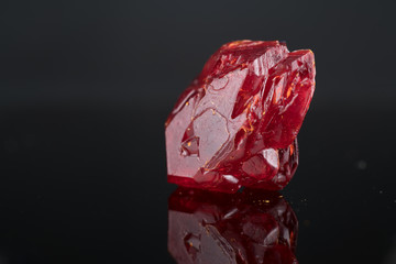 Red natural crystal mineral on a black background