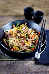 Rice noodles with fried beef, corn, green peas, red and green carrots, parsley and spicy sauce.