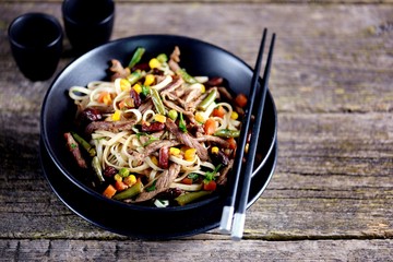 Rice noodles with fried beef, corn, green peas, red and green carrots, parsley and spicy sauce.