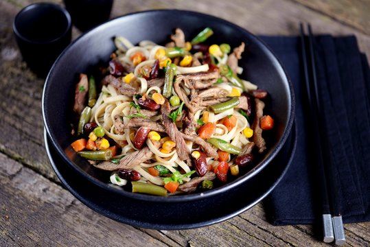 Rice noodles with fried beef, corn, green peas, red and green carrots, parsley and spicy sauce.